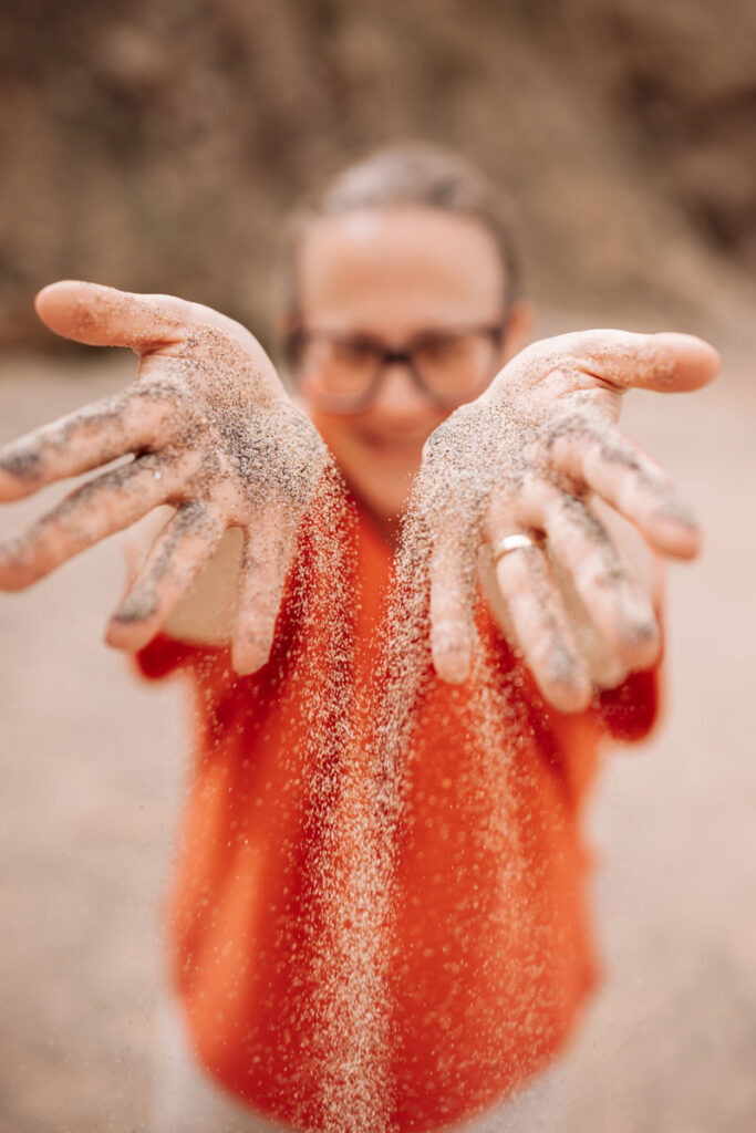 Karin Bergmann on the beach, sand trickles from her hands to the ground :: photo copyright Karin Bergmann