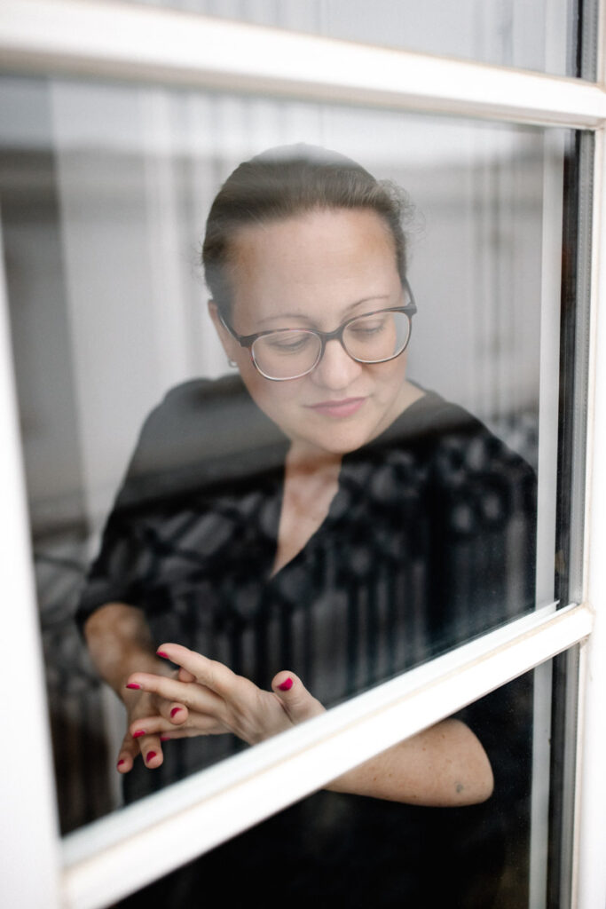 Karin steht am Fenster und blickt nachdenklich nach draußen :: photo copyright Karin Bergmann