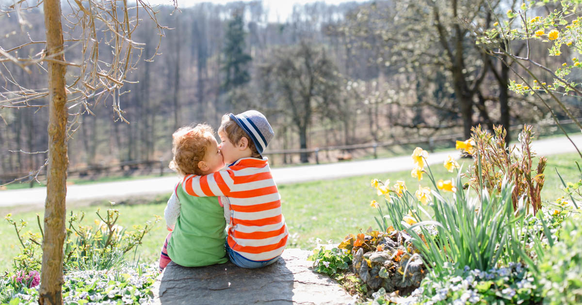 zwei entzückende Kleinkinder sitzen im Garten zwischen den Blumen :: photo copyright Karin Bergmann