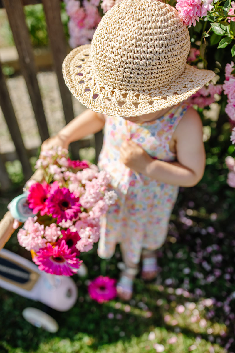 Family photos as a memory, young girl with summer hat and flowers in a basket, all in pink :: photo copyright Karin Bergmann