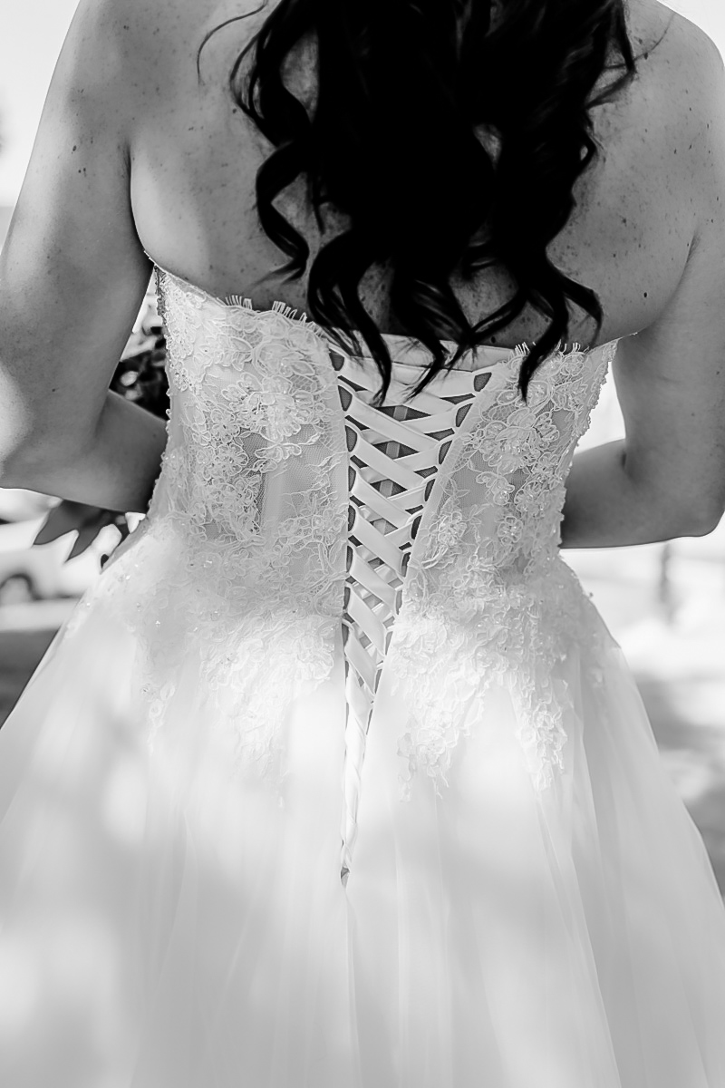 Hochzeitsfoto, Brau mit langen dunklen Locken, Kleid-Schnürung am Rücken, Detailaufnahme :: photo copyright Karin Bergmann