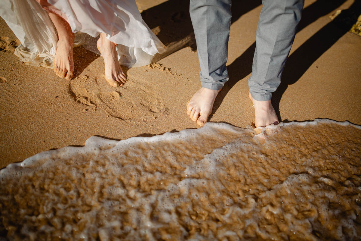 Hochzeitsfotos, Brautpaar mit den Füßen im Wasser an einem Strand der Algarve, Portugal :: photo copyright Karin Bergmann