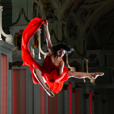 KBM Magazine Kunst in Bewegung, Tänzerin posiert in der Luft schwebend in der Alten Uni Graz - Lady in Red :: photo copyright Karin Bergmann