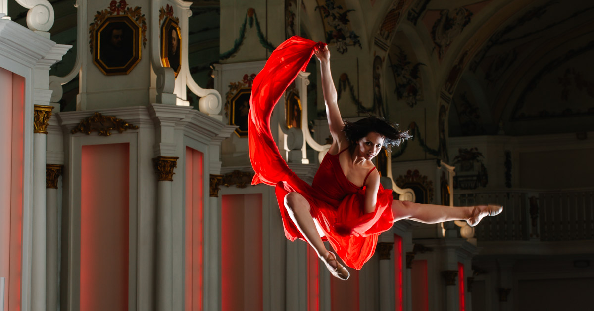 Kunst in Bewegung, Tänzerin posiert in der Luft schwebend in der Alten Uni Graz - Lady in Red :: photo copyright Karin Bergmann