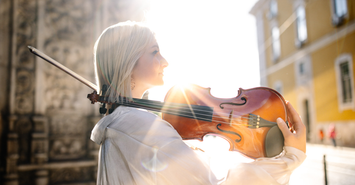 ausdruckstarkes Lifestyle Portrait, mit junge Frau mit Geige im morgendlichen Gegenlicht, Fotoshooting in einer Straße in Lissabon :: photo copyright Karin Bergmann
