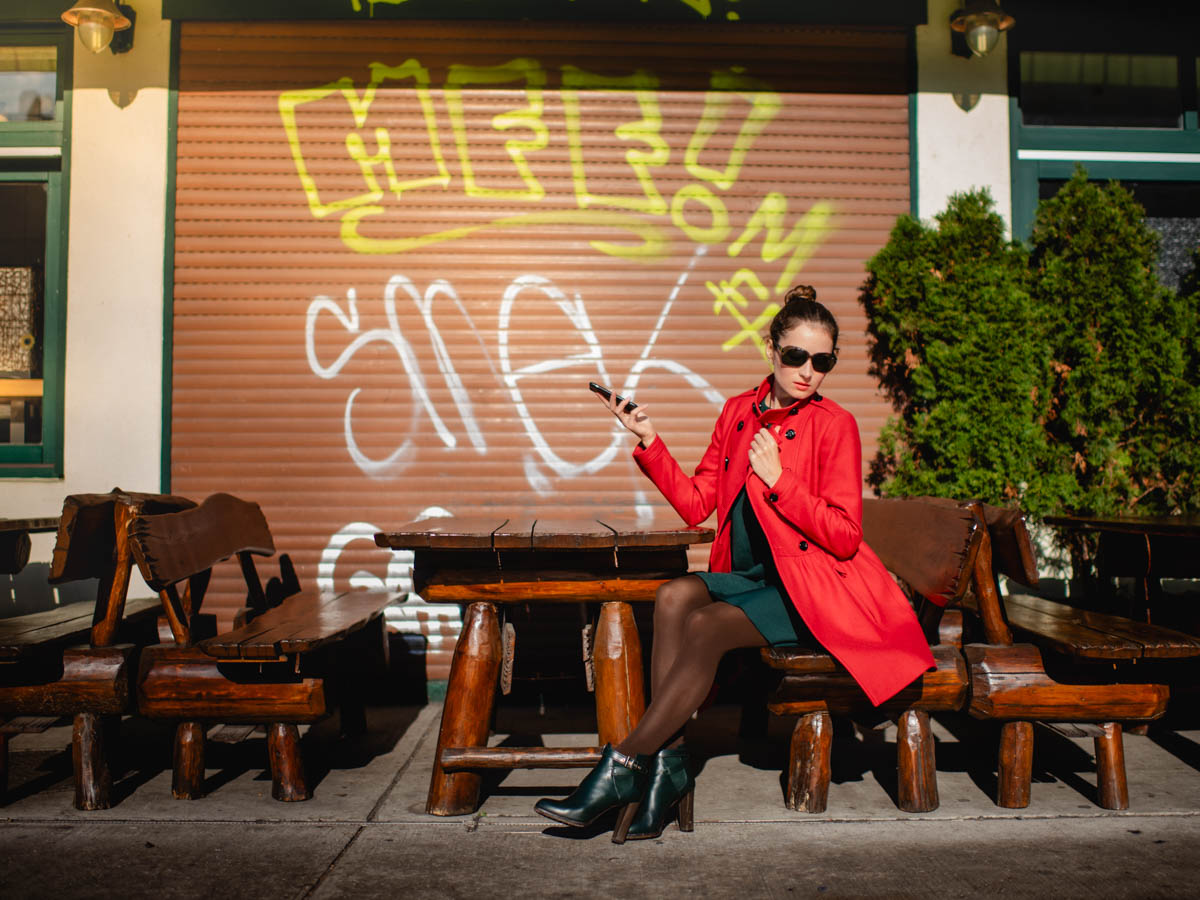 expressive lifestyle portrait photoshoot with extravagant woman with bright red coat in a beer garden in Munich, Germany :: photo copyright Karin Bergmann