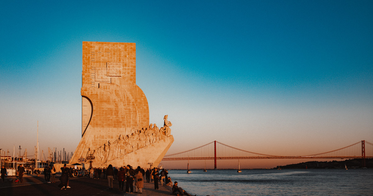 Lisbon, Monument to the Discoveries on the banks of the River Tagus, behind it the famous suspension bridge :: photo copyright Karin Bergmann